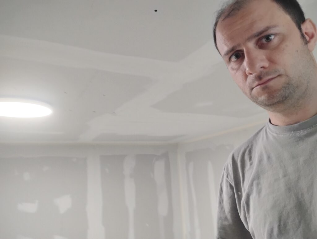 Contractor applying drywall mud during interior renovation project